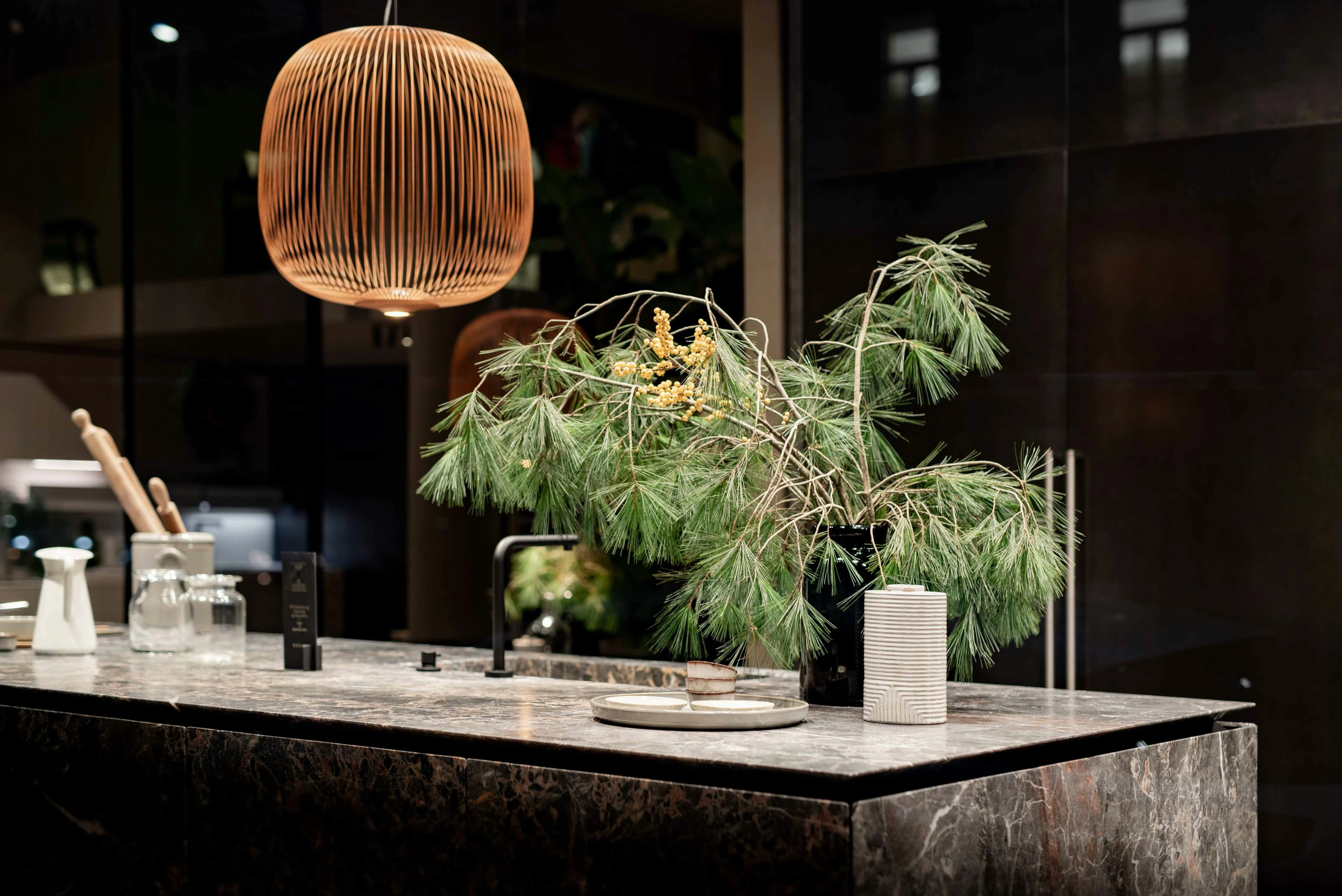 Dark stone kitchen island with a pendant light and marble worktop
